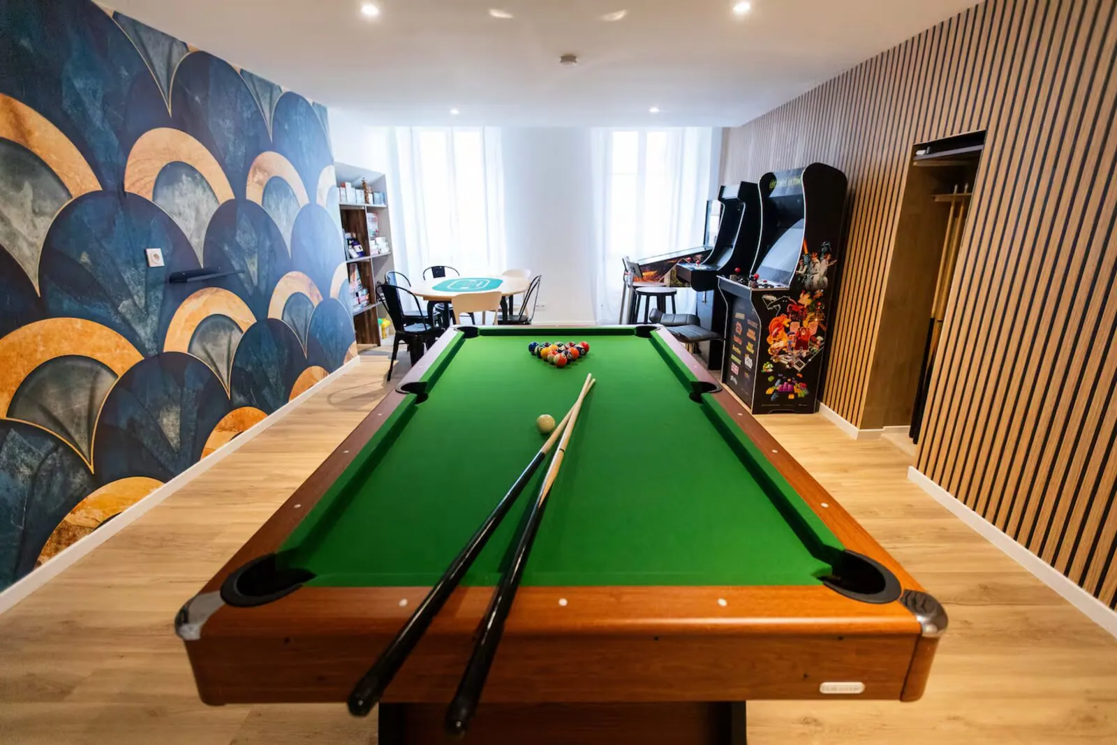 Salle Art Déco : billard en longueur, bornes d'arcade et table de poker devant fresque Art Déco – gîte groupe Var